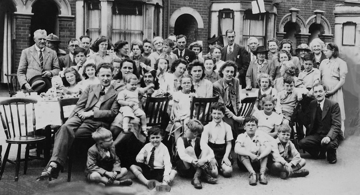 A large family gathered for a portrait on the street.